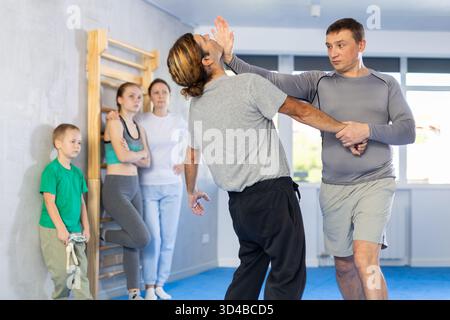 L'uomo in palestra esegue elementi di base del sistema di autodifesa krav maga. Foto Stock