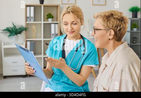 Donna anziana a consultazione con medico in ospedale, medico generico che parla con il paziente Foto Stock