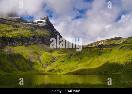 Cresta di montagna intorno al lago con nuvole che si insinuano a Bachalpsee, cui si accede facendo un'escursione da First, Oberland Bernese, Grindelwald, Switzlerland Foto Stock