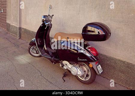 Vallila, Helsinki, Finlandia - 13 agosto. 2025: Vespa Primavera nera parcheggiata per strada a Helsinki. Foto Stock