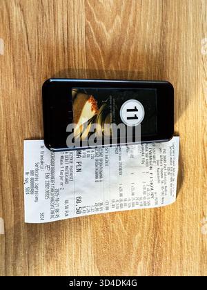 Nowy Dwor Mazowiecki, Polonia - 22 ottobre 2025: Uno smartphone si appoggia su una ricevuta di viaggio Foto Stock