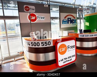 Nowy Dwor Mazowiecki, Polonia - 22 ottobre 2025: Luminoso banco di noleggio auto in un aeroporto affollato con marchio, segnaletica e design moderno. Foto Stock