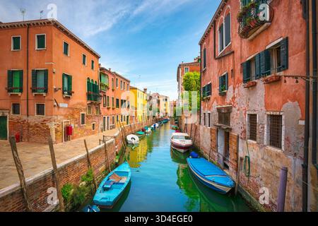 Affascinante e stretto canale di Venezia, caratterizzato da barche ancorate ed edifici colorati su entrambi i lati. Cielo azzurro luminoso sopra la fondamenta Trapolin creano Foto Stock