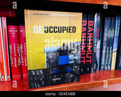 Kiev, Ucraina - 10 novembre 2025: Un libro intitolato De Occuped about Ukrainian Resistance on a Library shelf, copertina gialla. Foto Stock
