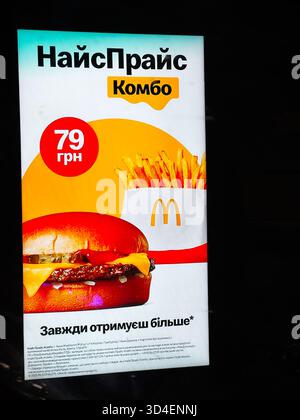 Kiev, Ucraina - 10 novembre 2025: Poster McDonald's luminoso in ucraino con hamburger, patatine fritte e prezzo in grivna. Foto Stock