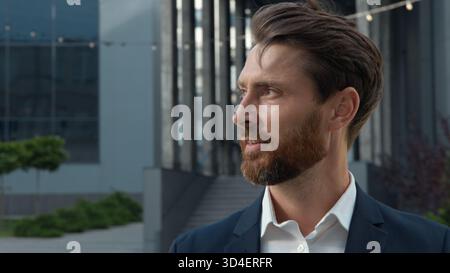 Ritratto ravvicinato sorridente uomo d'affari adulto caucasico di successo sorridere in città guardare lontano guardare la macchina fotografica gioioso uomo d'affari maturo imprenditore Foto Stock