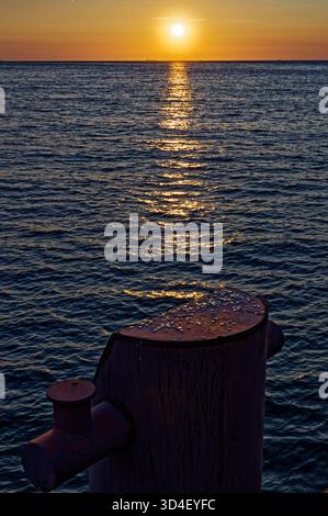 Tramonto dorato sul Mar Baltico visto dal molo. Foto Stock