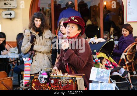PARIGI, FRANCIA - 29 DICEMBRE 2013: L'artista di strada Arlette Denis canta e suona l'organo a botte a Montmartre. Foto Stock