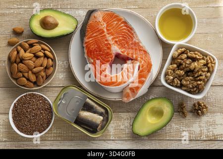 Cibo, fonti alimentari di acidi grassi insaturi, prodotti omega 3 e vitamina D, concetto di alimentazione e cottura sani. Sfondo in legno, vista dall'alto Foto Stock