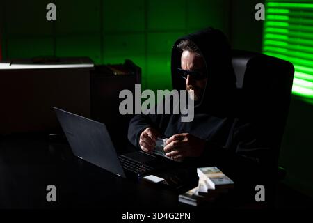 Hacking di criptovalute. Hacking alla ricerca di criptovalute. Hack alla criptovaluta. Hacker in tema di notte buia con cappuccio. Concetto di sicurezza dei dati digitali Foto Stock