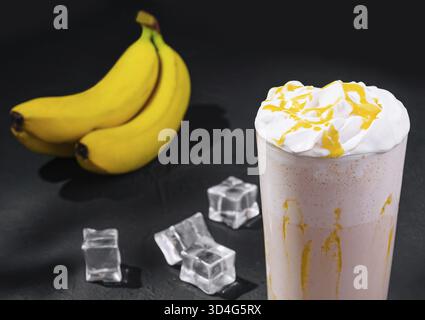 Cibo, deliziosi frullati su pietra nera con cubetti di ghiaccio Foto Stock