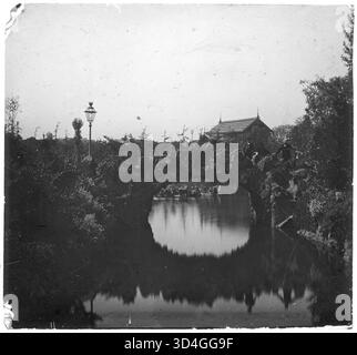 Una vista parziale del lago nel Parco della Ciutadella di Barcellona, fotografata da Màrius Aguirre i Serrat-Calvó tra il 1888 e il 1910. Le tranquille acque del lago sono incorniciate dal parco circostante e dagli alberi, riflettendo la serena bellezza di questo spazio pubblico. Foto Stock