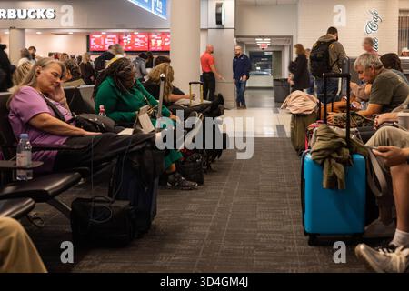 SAVANNAH, GEORGIA, Stati Uniti, 9 NOVEMBRE 2025: I passeggeri delle compagnie aeree aspettano in un'area affollata di gate terminal, con un po' di sonno o riposo, a Savannah/Hilton H. Foto Stock