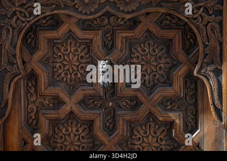 Porta in legno con pomello decorativo, a battente progettato a forma di mano umana. Porta tradizionale a bussare nella strada del quartiere medina, Marrakech. Foto Stock