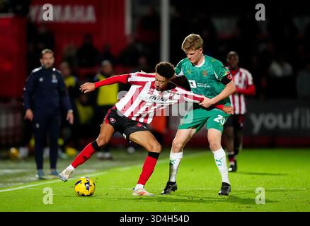 Jonathan Tomkinson (a sinistra) di Cheltenham Town e Scott Robertson (a destra) di Notts County combattono per il pallone durante la partita Sky Bet League Two all'EV Charger Points Stadium, Cheltenham Data immagine: Lunedì 10 novembre 2025. Foto Stock