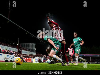 Scott Robertson (a sinistra) della contea di Notts e Jonathan Tomkinson (centro) del Cheltenham Town si battono per il pallone durante la partita Sky Bet League Two all'EV Charger Points Stadium, Cheltenham Data immagine: Lunedì 10 novembre 2025. Foto Stock