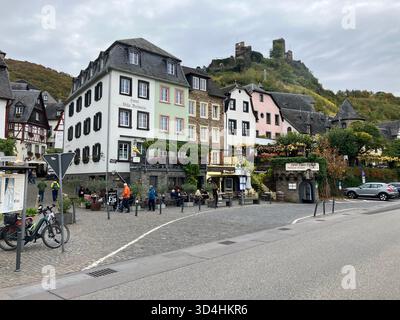 Le rovine del castello di Metternich si affacciano su edifici storici colorati e caffè lungo la strada nel villaggio di Beilstein, Cochem-Zell, Germania. Foto Stock
