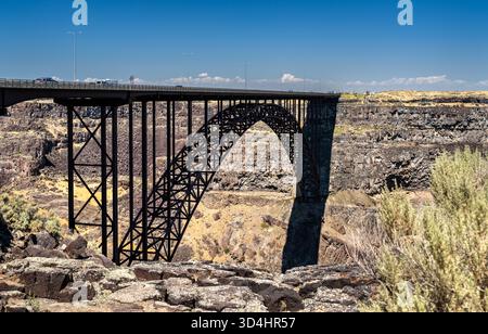 Vista dell'arco del Perrine Bridge a Twin Falls, Idaho. La struttura in acciaio attraversa le profonde scogliere basaltiche del canyon del fiume Snake sotto un cielo azzurro. Rappresenta l'ingegneria e l'infrastruttura Foto Stock