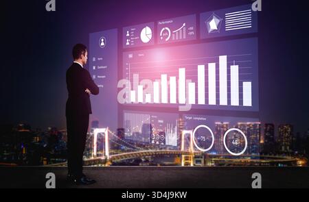 Un uomo d'affari si trova davanti a uno schermo digitale trasparente che mostra le visualizzazioni dei dati rispetto a uno straordinario paesaggio urbano notturno, mettendo in evidenza le prestazioni Foto Stock