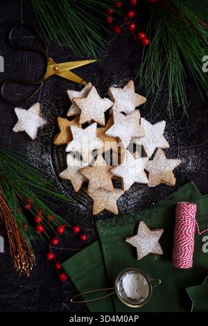 Biscotti a forma di stella con biscotti di pasta frolla in un ambiente festivo. Foto Stock