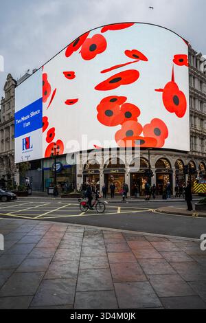 Londra, Regno Unito. 11 novembre 2025. Il maltempo autunnale fa sì che molti passanti non guardino in alto, figuriamoci fermarsi, purtroppo: Le Piccadilly Lights di Londra vengono messe in pausa l'11 novembre, quando lo schermo, gestito da Ocean Outdoor per Landsec, viene rilevato dalla Royal British Legion. Evidenzia i due minuti di silenzio e consente alle persone un momento di pausa e di riflettere mentre la nazione si riunisce per ricordare “coloro che hanno dato così tanto per la libertà che godiamo oggi”. Crediti: Guy Bell/Alamy Live News Foto Stock