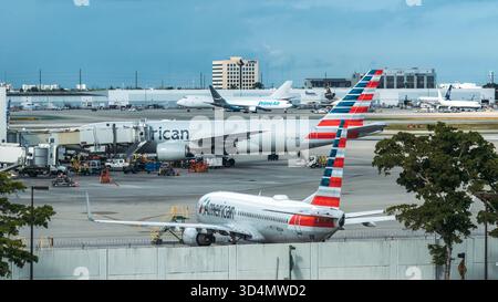 Giornata intensa all'aeroporto internazionale di Miami con aerei in preparazione al decollo e all'arrivo Foto Stock