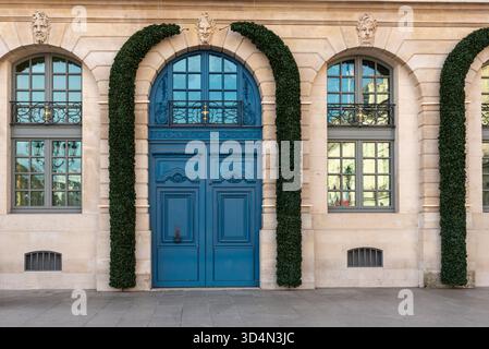 Bella porta blu e facciata di un edificio in Place Vendôme nel primo arrondissement di Parigi. Decorazioni natalizie intorno a una porta di legno Foto Stock