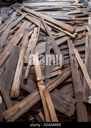 pile di vecchie tavole di legno rotte all'interno della torre svan dopo il crollo del tetto dell'edificio Foto Stock