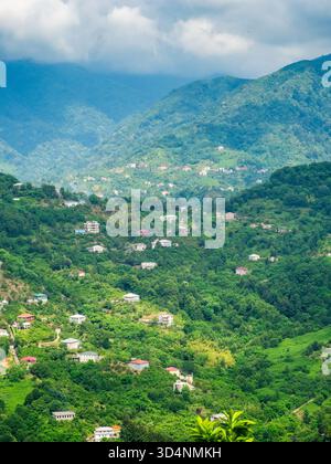 Sopra la vista del villaggio nella valle di montagna nei sobborghi della città di Batumi dal monastero di Tsminda Sameba sul Monte Sameba il giorno d'estate, Georgia Foto Stock