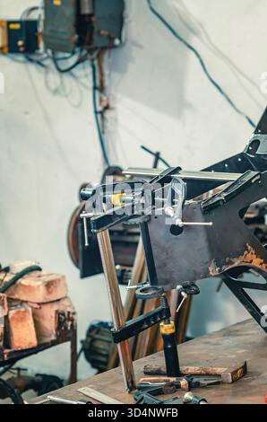 Il morsetto metallico tiene insieme le parti in ferro. Preparazione delle parti metalliche per la saldatura. Informazioni generali sulle officine industriali. Foto Stock