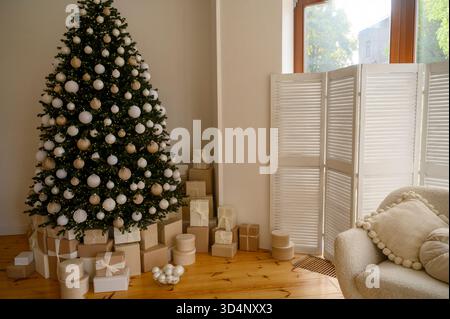 Splendidamente decorate albero di Natale con molti presenta al di sotto di esso. Foto Stock