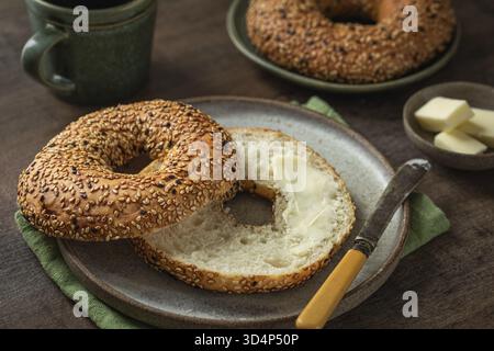 Cibo, bagel appena sfornati con burro, sano concetto di colazione, sfondo in legno Foto Stock