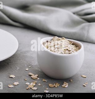 Cibo, fiocchi d'avena arrotolati secchi sulla ciotola Foto Stock