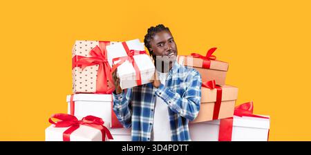 Collage creativo con un giovane che regge una confezione regalo in mezzo a regali colorati Foto Stock