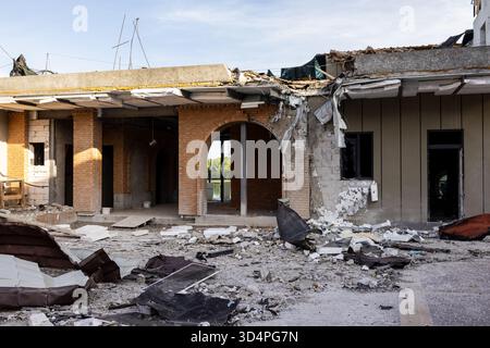 Vista aerea del tetto e della facciata in cemento in mattoni crollati strappati, isolamento e macerie sparse sul terreno, arco e telaio della finestra Foto Stock