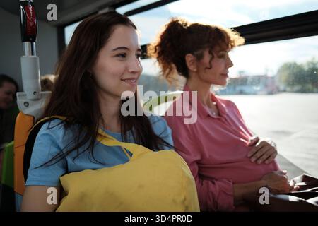 Donna incinta e figlia che viaggiano in autobus Foto Stock