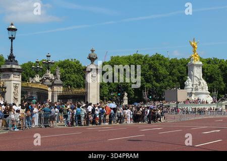 La folla si raduna fuori da Buckingham Palace a Londra, godendosi il sole e i luoghi storici durante l'estate Foto Stock
