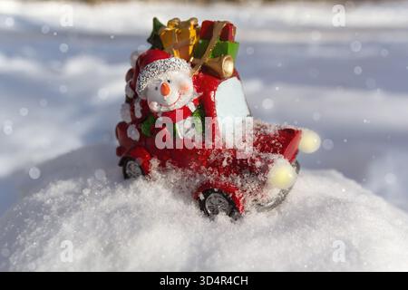 Allegro pupazzo di neve giocattolo su un'auto porta regali. Giocattolo di Natale Foto Stock