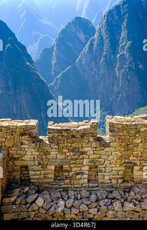 Dettaglio delle pareti in pietra della costruzione Inca, lavori in pietra in contrasto con il paesaggio delle montagne del Canyon Urubamba, rovine di Machu Picchu, Perù Foto Stock