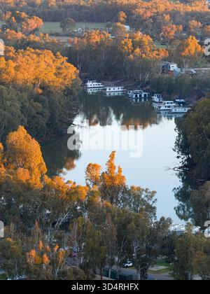 Vista aerea delle case galleggianti su un ampio fiume che si snoda attraverso una foresta di gomme al crepuscolo a Moama sul fiume Murray nel nuovo Galles del Sud, Australia. Foto Stock
