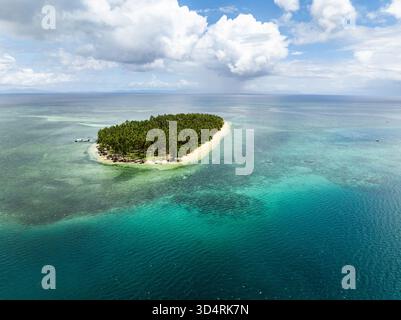 Isola remota coperta da palme circondata da acque turchesi e dalla barriera corallina. Siargao, Filippine. Casa desiderio. Foto Stock