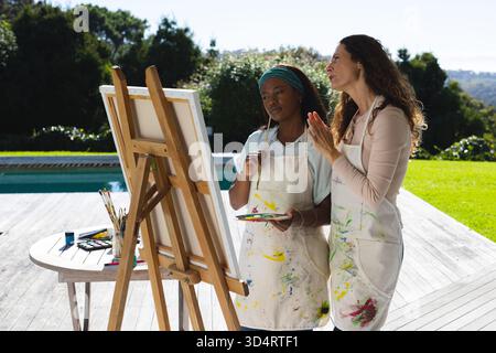 Dipingere diverse istruttrici e studentesse all'aperto sulla terrazza vicino alla piscina, con teglie ad acquerello Foto Stock