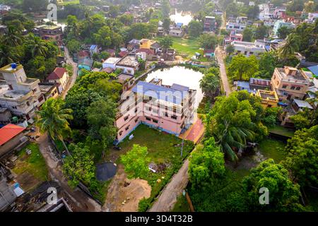 Vista dall'alto delle case suburbane indiane con pannelli solari sul tetto e alberi intorno. Foto Stock