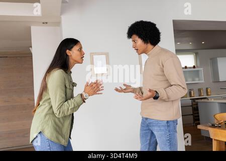 Discutere diverse coppie in piedi in interni a pianta aperta, con armadi bianchi e porte in legno Foto Stock