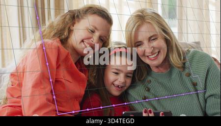 Tre donne in corallo, maglia verde, fascia rossa, telefono sul divano di casa, griglia viola Foto Stock