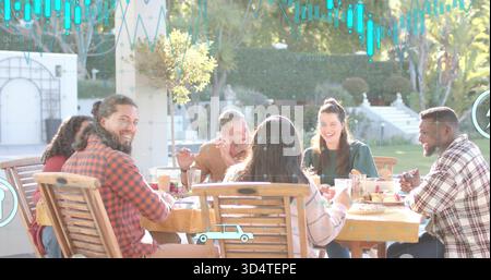 Ridendo sei adulti che condividono il pasto nel patio sul cortile, indossando abiti informali e un tavolo di legno Foto Stock