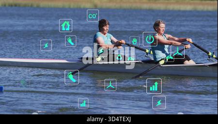 Canottaggio di 2 donne in top azzurro con remi manici gialli in conchiglia sul lago, mostrando icone HUD Foto Stock