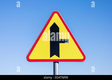 Incrocio con una strada laterale sulla destra - cartello polacco su sfondo blu. Foto Stock