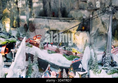 Località sciistica invernale in miniatura con funivia, montagne innevate, pini e scuola di sci in un'esposizione dettagliata delle vacanze. Villaggio di Natale Foto Stock