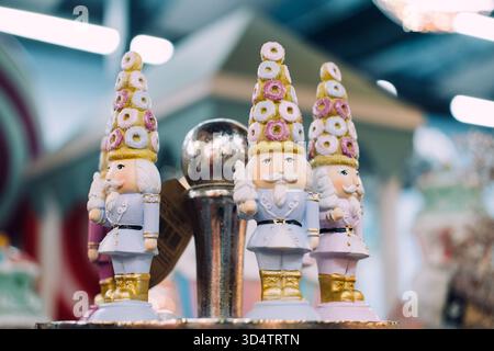 Statuette di schiaccianoci a tema caramelle con uniformi pastello e cappelli di ciambella in mostra natalizia. Varsavia, Polonia, 20 novembre 2024 Foto Stock